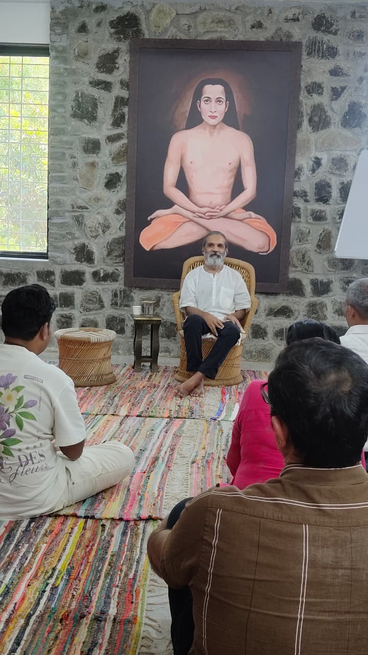 Satsang with Tarun Pradhaan at Tapovan, seekers seated before a portrait of Babaji